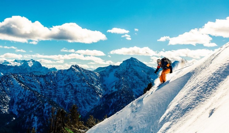 Ein Skifahrer fährt in seinem Kurzurlaub im Chiemgau einen Berg hinunter