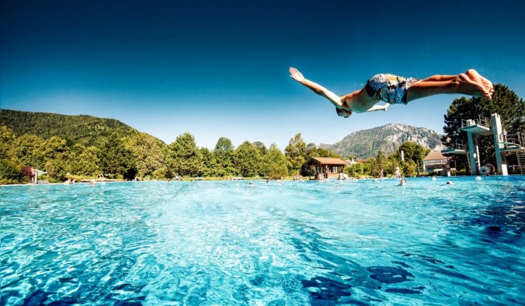 Ein Kind springt während des Vitalurlaubs in Bayern in einen Pool