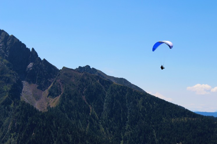 Eine Paraglider macht Sommerurlaub in Ruhpolding und schwebt über die Berge