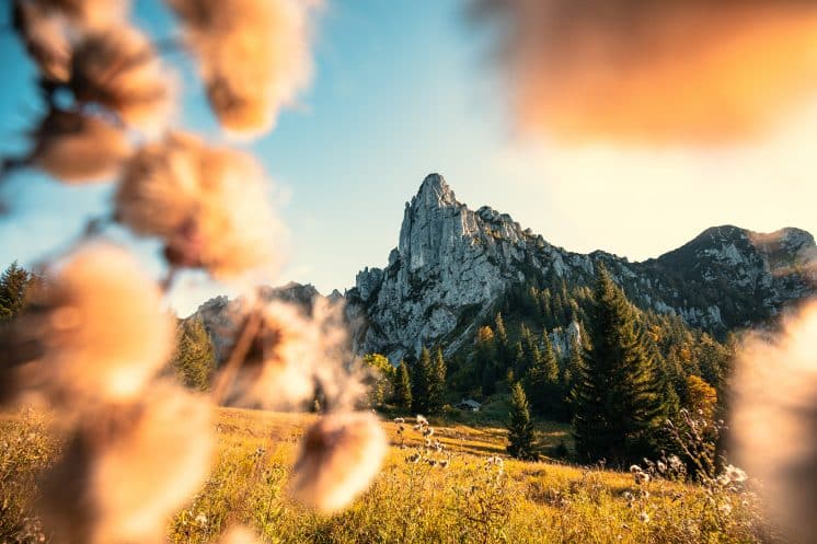 Ein imposanter Berggipfel mit schroffen Felswänden, bescheint von der untergehenden Sonne